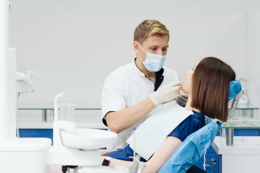 Dentist examining a patient during a dental crown consultation at a modern dental clinic in Reading, MA.