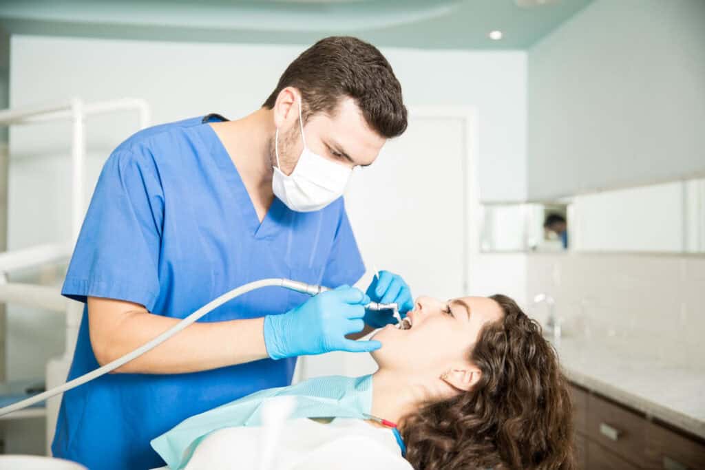 Dentist performing root canal therapy on a patient in a modern dental clinic.